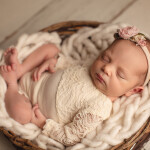 новорожденный ребенок в круглой плетеной корзине