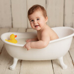 ребенок купается в ванночке с уточкой